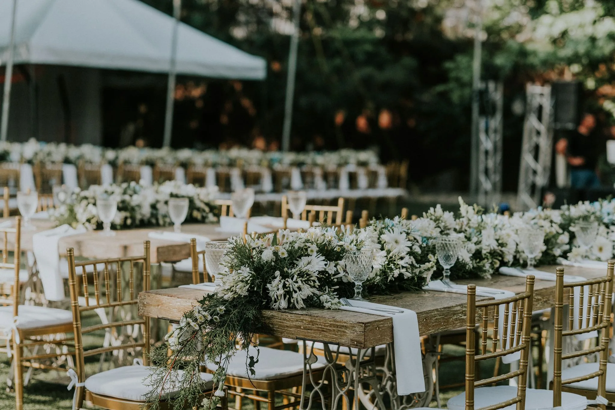 Outdoor garden reception with white florals and gold chiavari chairs