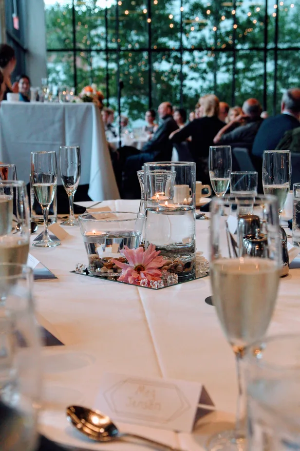 Hotel dining table with a floating-candle centrepiece beside tall windows