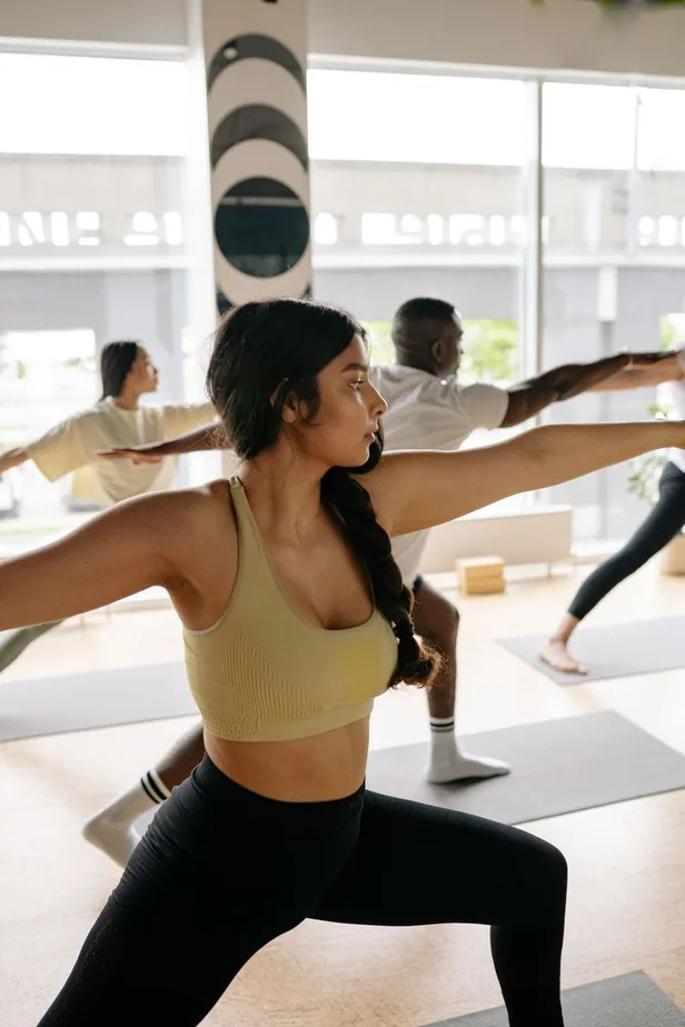 A group holding warrior pose during a wellness event