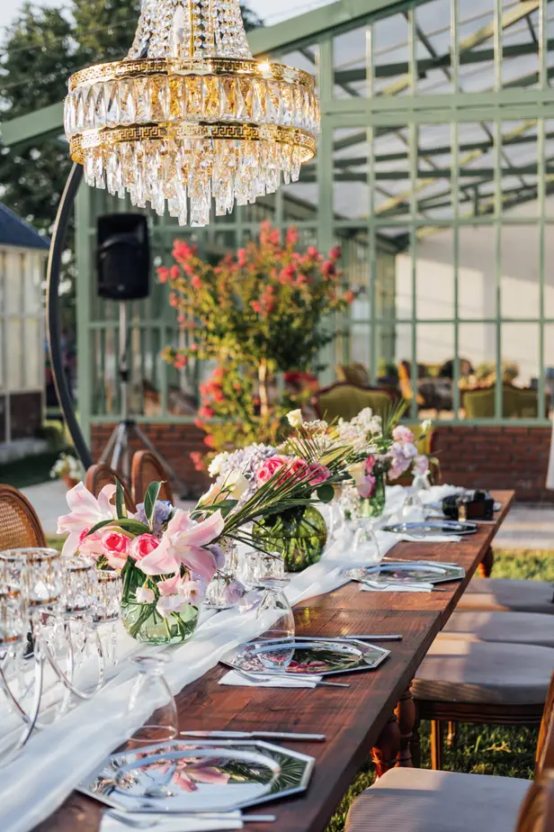 Greenhouse dinner table set under a crystal chandelier