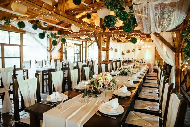 Long table in a rustic timber room dressed with greenery and candles