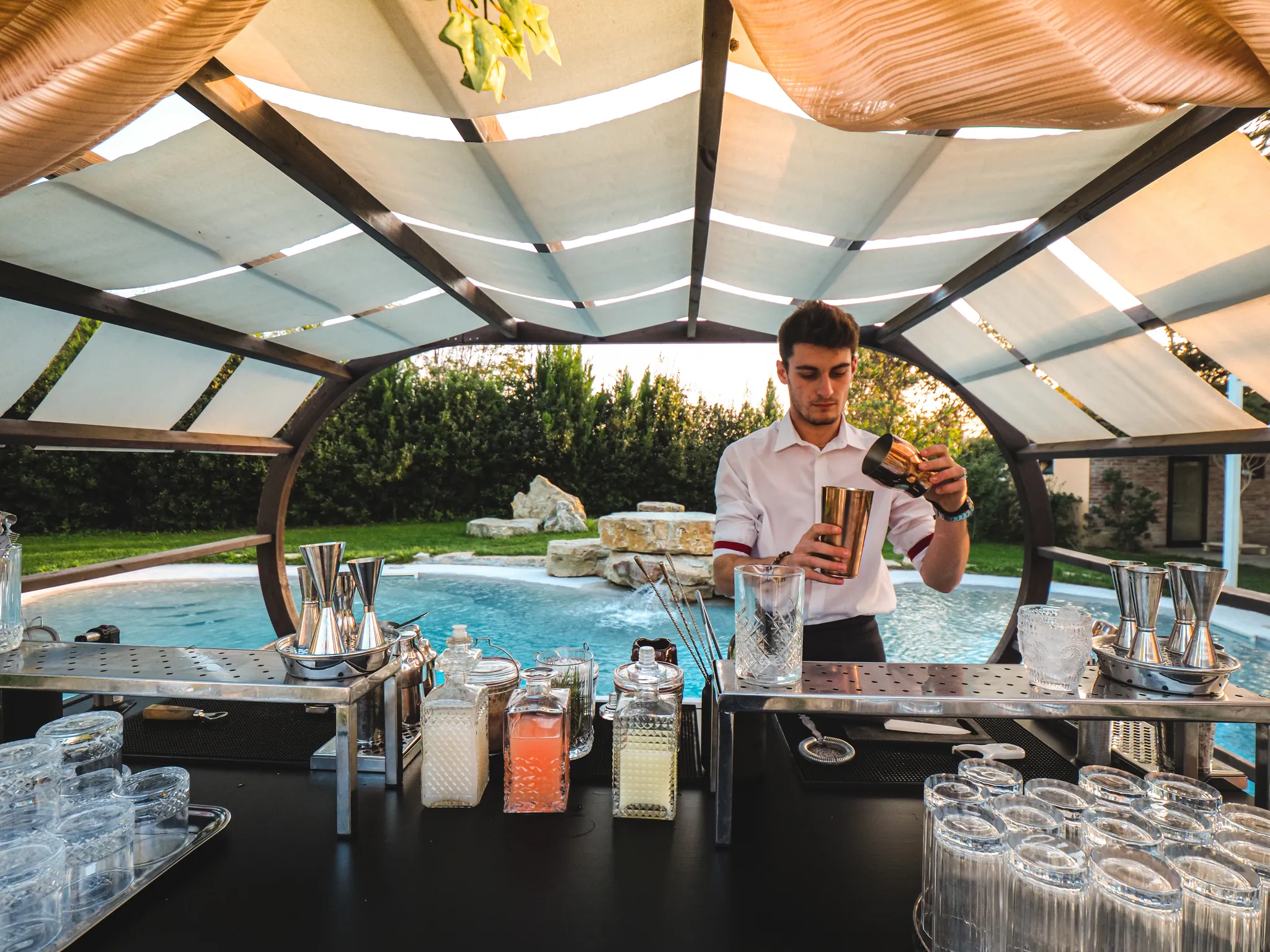 Barman mixing cocktails at a poolside party