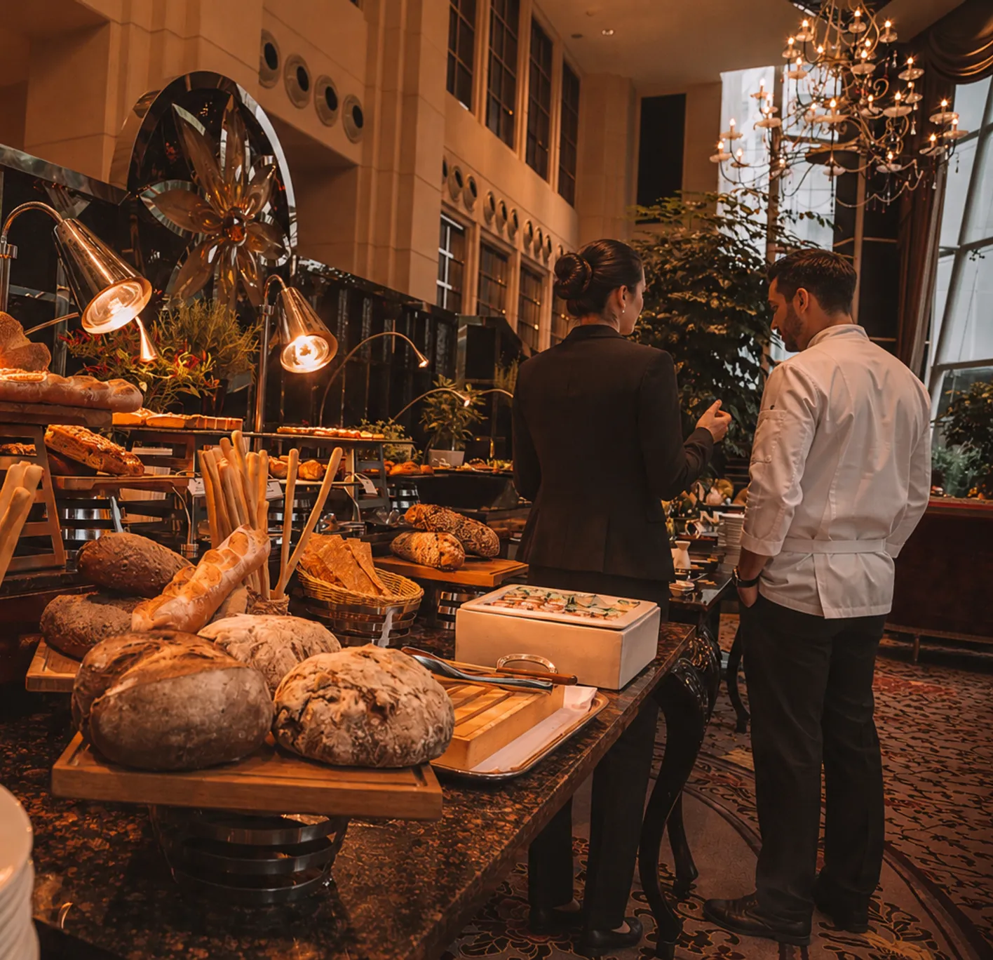 Banquet buffet of breads and canapes reviewed by an event manager and a chef